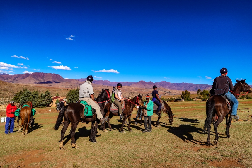 horse riders in Malealea take a break in front of some mountains in Malealea, Lesotho, Southern Africa, photo by Kelly Benning