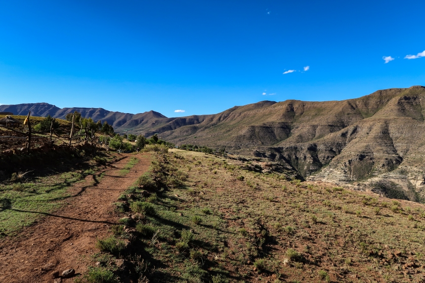 a dirt road through rural Malealea surrounded by mountains, Lesotho, Southern Africa